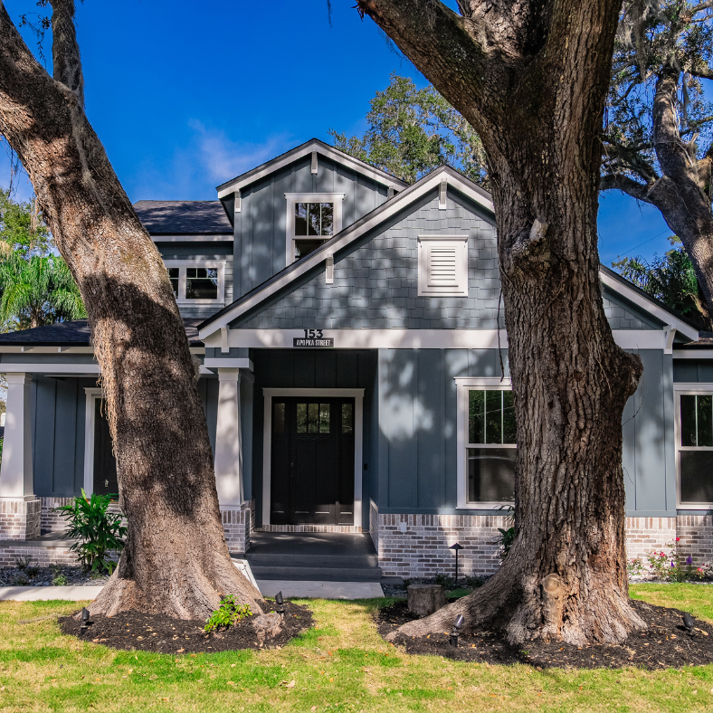 Custom home with beautiful trees in front yard.